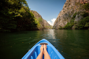 Fototapeta Kayaking through river in Matka canyon, Macedonia. Woman legs in the blue kayak obraz