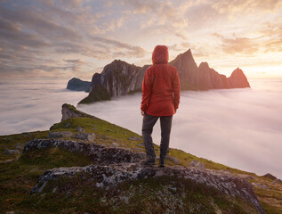 A tourist enjoying a view at the Mountain Hesten, Senja, Norway. Trekking in Norway, active life concept