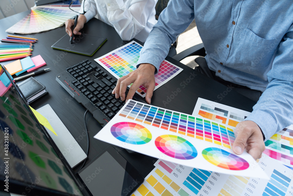 Aufkleber graphic designer or creative working together coloring using graphics tablet and a stylus at desk wi