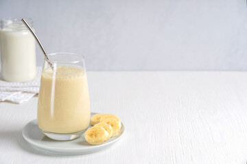 Smoothie or milkshake made of ripe sweet banana fruit blended and mixed with milk served in...