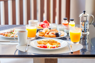 Breakfast Buffet in Luxury Hotel, Omelette and Fresh Desserts, Buns, Croissant. Dining Table with Plate of Delicious Food. Food in Hotel with Plates Full of Food, Orange Juice in Glass and Coffee Cups