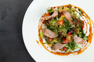 salad with tongue in a plate on a dark background