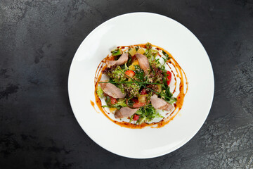salad with tongue in a plate on a dark background