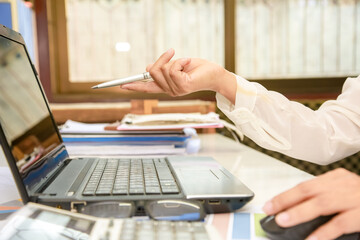businessman hands searching for data on Notebook with analyzing charts at his workplace.