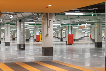 Rows receding into distance in underground parking lot under shopping center.