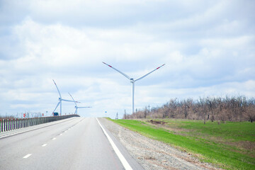 Windmills along the road. Windmills generate electricity. Wind power plant. Wind farm, green energy