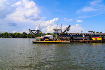 a shot of the dredging rig in the Savannah River with vast river water, blue sky and clouds in...