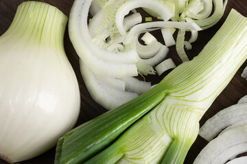 fresh onion cut into half rings on a dark cutting board close-up. Cooking concept

