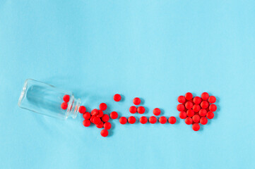 Red pills scattered bubble on a blue background in the form of a cardiogram and a heart with place for text. medicine concept