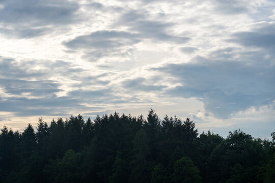 Wolken &uuml;ber einem H&uuml;gel mit Wald
