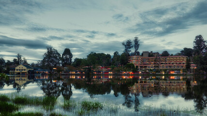 View of the town from the lake during the evening time with trees and plants around the water lake....