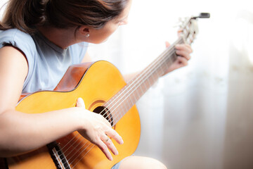 Mujer tocando guitarra española sobre fondo blanco