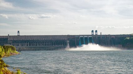 Discharging water to hydroelectric power station in Krasnoyarsk, Russia. Industrial landscape with Krasnoyarsk Dam at sunny day.