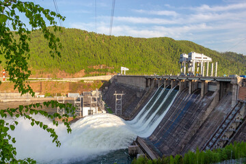 Strong flow of water when discharging water to hydroelectric power station in Krasnoyarsk, Russia. Industrial landscape with open locks on Krasnoyarsk Dam at sunny day.