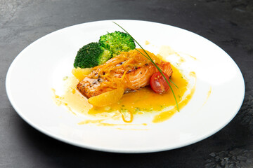 salmon steak in orange sauce and broccoli. In a plate