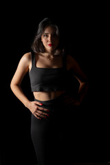 Portrait of attractive a young woman with cinematic lighting. Woman wearing a suspender bodysuit. Half naked sexy woman. Vertical shot.