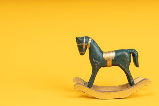 Blue vintage rocking horse on yellow background