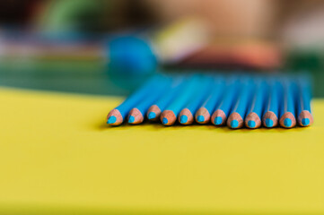 Sharpened blue pencils on a yellow background.