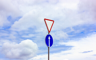 Grant right of way traffic sign against blue sky. A priority sign for drivers.