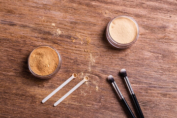 Mineral powder foundation with brushes on a wooden background. Eco-friendly and organic beauty products
