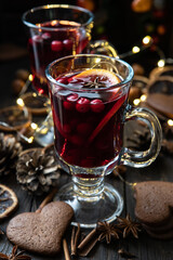 Christmas hot drink with citrus and  cranberry  in glass.  Christmas and winter warming beverage