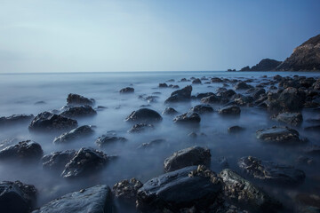 Beach water waves with Slow shutterspeed and lots of rocks visible