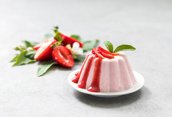 Panna Cotta strawberry with sauce on a plate on a light background