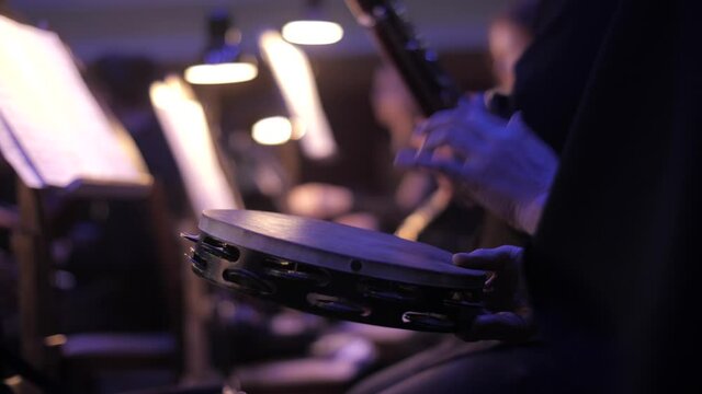 The musician plays the tambourine