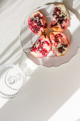 The background is white with shadows from a crystal glass, pomegranate.