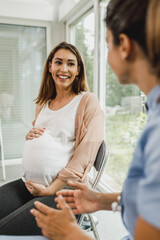 Pregnant Woman Talking To Gynecology Nurse At Waiting Room