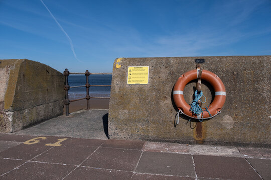 Red lifebelt and steps to beach at the promenade New Brighton Wirral May 2021
