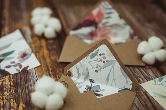 Floral lined envelopes next to cotton flowers