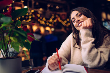 Cheerful woman with notepad and pen toothy smiling at camera