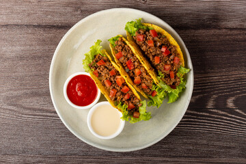 Mexican tacos with lettuce, beef and tomatoes.