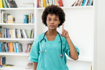 Afro american female nurse gesturing stop and attention