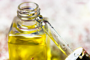 Pipette with liquid oil in a glass transparent bottle to moisturize a cuticle. Essence for skin...