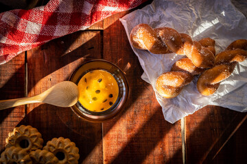 pote de geleia visto de cima em mesa de madeira com pães © Riberto Frederico