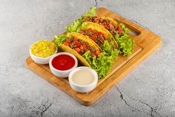 Mexican tacos with lettuce, beef and tomatoes.