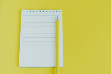 Top view image of an open notebook with blank pages. school notebook on yellow background