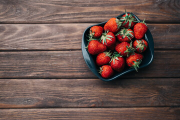 Ripe strawberry on a wooden background and nothing more, for copy-space.