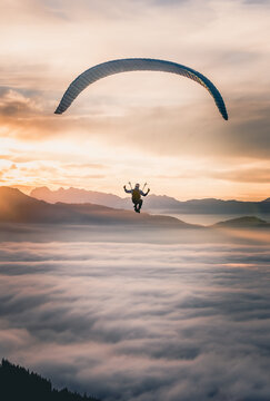 Man Paragliding above the clouds at sunset, Salzburg, Austria