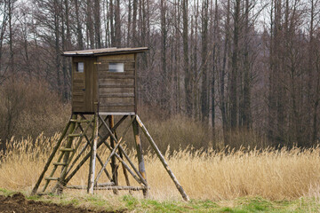 Wooden lookout tower for hunting in the woods and on meadow