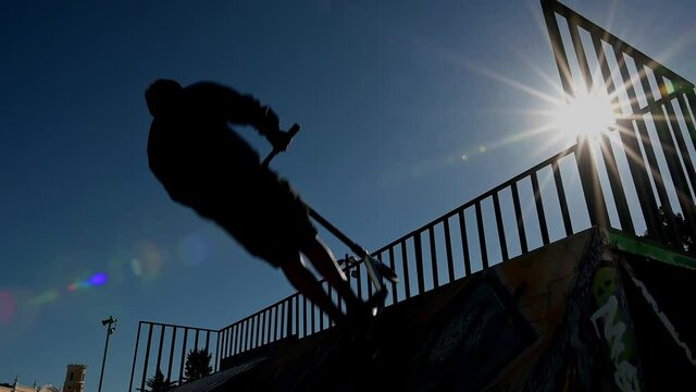 Skate park in Lisbon, silhouette of skater using the half pipe 