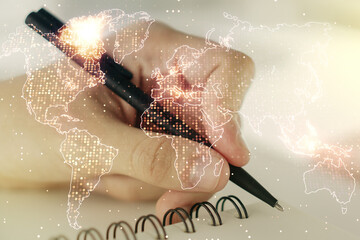 Abstract creative world map and man hand writing in notebook on background, international trading concept. Multiexposure