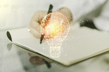 Creative light bulb illustration with hand writing in notepad on background, future technology concept. Multiexposure