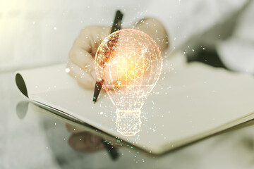 Creative light bulb illustration with hand writing in notepad on background, future technology...