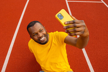 Handsome young afro american sportsman athlete runner is taking selfie at the stadium location....