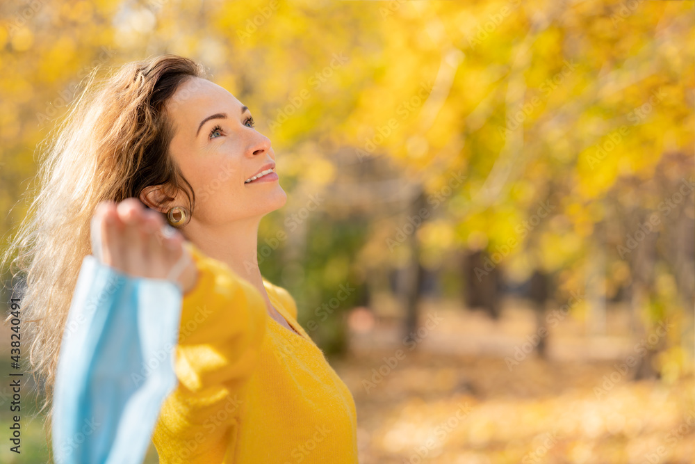 Sticker happy woman wearing protective mask in autumn park