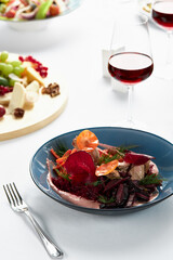 Hummus with vegetables, beetroot hummus with fried vegetable sticks and svela leaves, with a glass of wine on the festive table