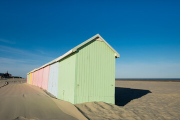 Multicolored beach huts lined up on the deserted beach of Berck in France